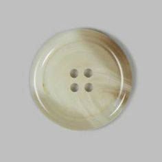 a white button with four holes in it on a gray background, showing the three buttons