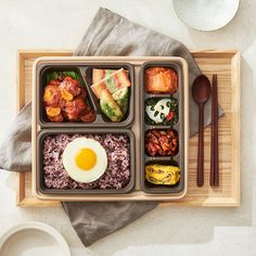 an overhead view of a bento box with eggs, rice and other foods in it