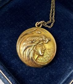 This is a gorgeous antique gold filled Victorian - Art Nouveau locket pendant necklace which features a beautiful goddess maiden woman with extraordinary flowing hair. This is one of the most beautiful images of a goddess woman we have seen on a locket. It is a sensitive romantic but strong depiction of womanhood! Her hair is magnificent as it swirls in the wind around her face. On the reverse is a fabulous initial monogram which I believe is MFH. The locket hangs from a fabulous gold filled chain. The locket and necklace are in wonderful condition. The necklace dates to circa 1890-1920. The locket opens to reveal places for two photos. The wonderful locket dances delightfully around the neck. Goddess maiden inspired jewels as well as lockets are all the rage today and finding one of this Art Nouveau Gold Collectible Jewelry, Collectible Art Nouveau Gold Jewelry, Art Nouveau Engraved Gold Jewelry, Gold Cameo Jewelry In Art Nouveau Style, Gold Engraved Art Nouveau Jewelry, Art Nouveau Medallion Necklace Engraved, Art Deco Medallion Locket Jewelry, Art Deco Yellow Gold Locket Necklace, Collectible Art Deco Locket Necklace