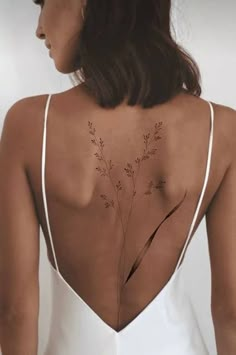 the back of a woman's body with small flowers on her upper and lower back