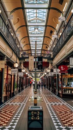 the inside of a shopping mall with people walking around