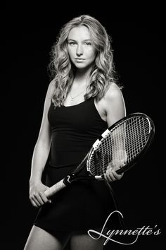 a black and white photo of a woman holding a tennis racket