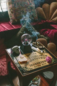 a table with some writing on it next to a teddy bear and other items in front of a couch