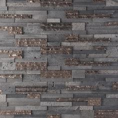 a close up view of a wall made out of blocks of grey and brown bricks