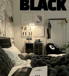 a bed room with a neatly made bed and pictures on the wall above it that says black