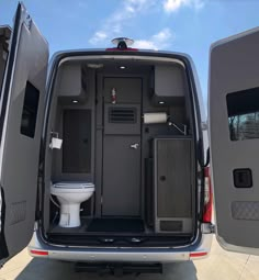 an open van with the back door opened and toilet in it's place inside