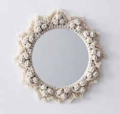 a white circular mirror hanging on the wall