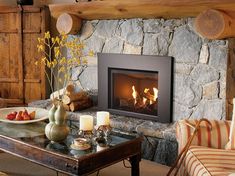 a living room filled with furniture and a fire place next to a stone wall mounted fireplace