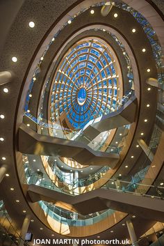 the inside of a building with glass and metal spiral design on it's ceiling