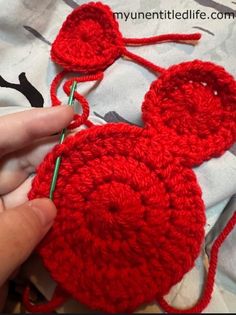 crocheted mickey mouse hat being worked on by someone using the knitting needle to make it