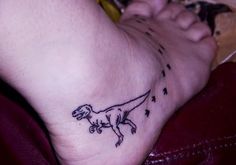 a small dinosaur tattoo on the foot