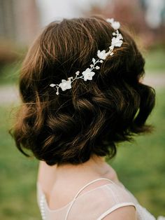 a close up of a woman wearing a hair comb with flowers on it's head