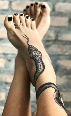 a woman's foot with a snake tattoo on it