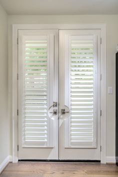 two white double doors with blinds on them in a home's entryway area