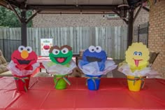 three sesame street cupcakes sitting on top of a red table