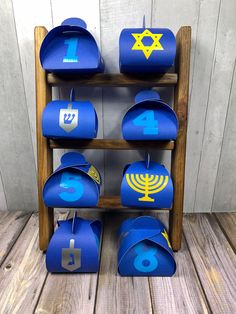 a wooden shelf filled with lots of blue paper hats and numbers on it's sides