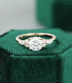 an engagement ring sitting on top of a green box