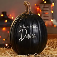 a black pumpkin with the words spooky trick or treat on it sitting in hay