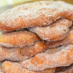 a pile of sugar covered donuts sitting on top of each other