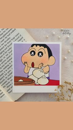 a card with an image of a cartoon character on it, sitting next to a book