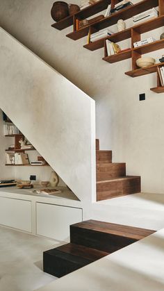 the stairs are made of wood and have bookshelves on each shelf above them