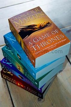 a stack of books sitting on top of a wooden table