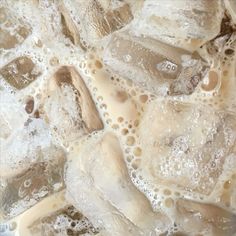 ice cubes and water are being mixed together in a liquid filled dish with bubbles