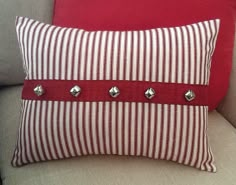 a red and white striped pillow sitting on top of a couch