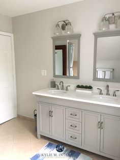 a bathroom with two sinks, mirrors and a rug on the floor in front of it