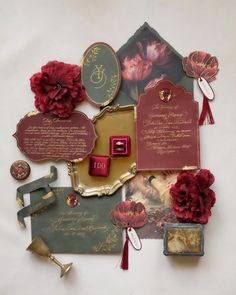 an assortment of decorative items displayed on a white tablecloth with red and gold accents