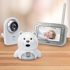 an electronic baby monitor with a teddy bear on the screen and a digital camera next to it