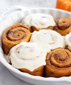 cinnamon rolls with icing in a white dish