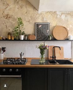 a kitchen with an oven, sink and shelves above the stove is decorated with flowers