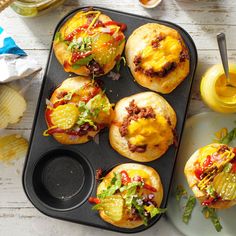 mini burgers with cheese and toppings in a muffin tin