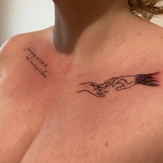 a woman with a tattoo on her chest holding the hands of another person's hand