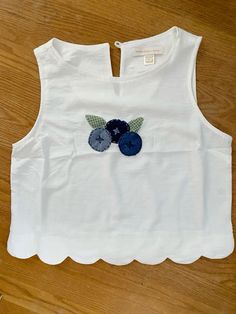 a white top with blue flowers on it