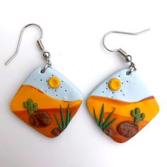 the earrings are decorated with desert scenes