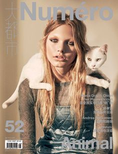 a woman holding a cat on the cover of numero magazine