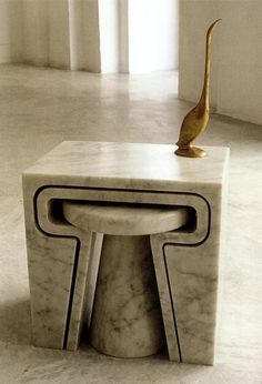 a marble bench with a gold bird statue on top