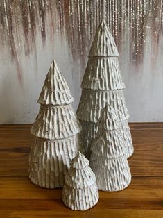 three white ceramic trees sitting on top of a wooden table