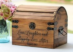 a wooden box sitting on top of a table next to a vase filled with flowers