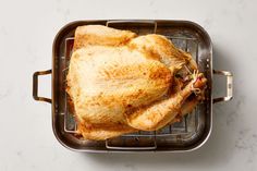 a roasting pan with a whole chicken in it