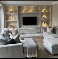 a living room filled with furniture and a flat screen tv mounted on a wall above it