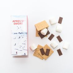 an assortment of marshmallows and crackers on a white surface next to a box of apricots