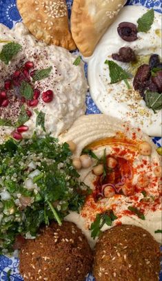 several different types of food on a blue and white platter, including pita bread