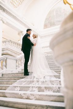 a bride and groom are standing on the stairs