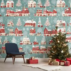 a christmas tree in front of a wallpaper with houses and trees