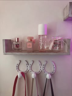 three pairs of scissors are hanging on a shelf with perfume bottles and other items in the background