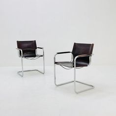 two chairs sitting next to each other on a white floor