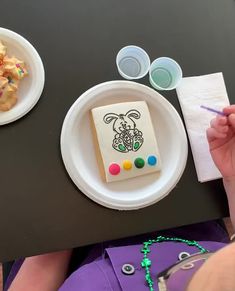 a person sitting at a table with some food on the plate and other items in front of them